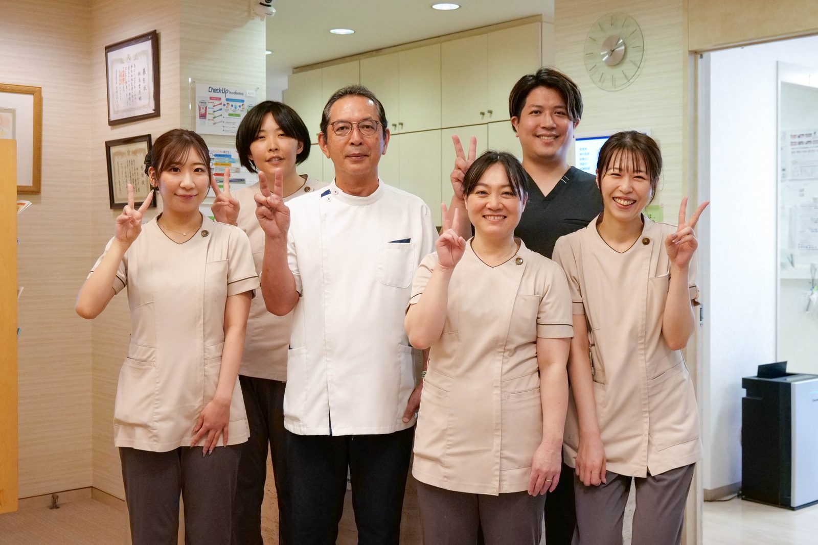 笑顔でピースをする高畑中央歯科のスタッフ